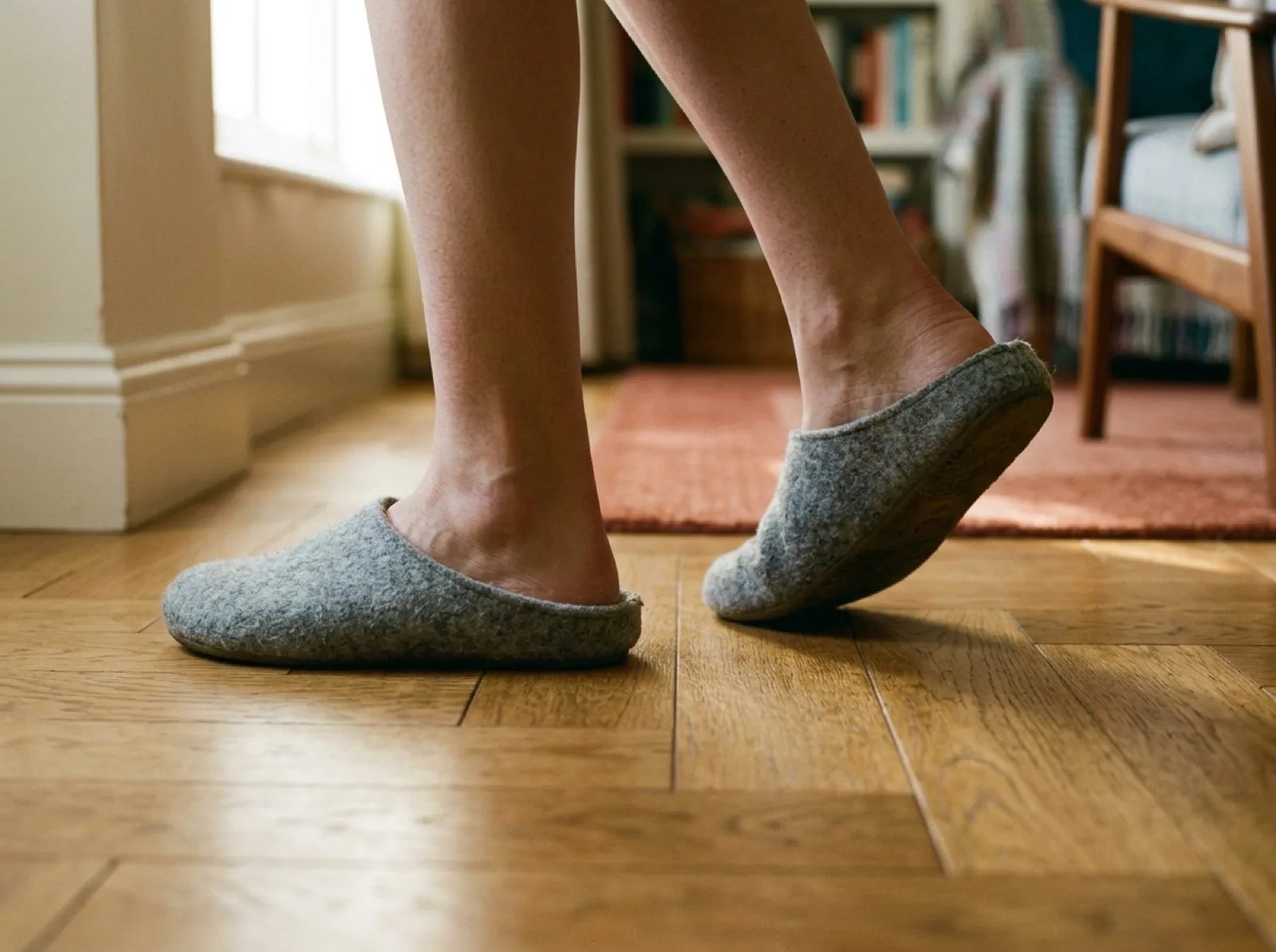 Des pieds en chaussons qui reprennent la marche sur un parquet
